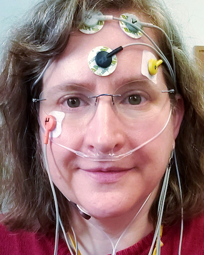 Sleep study participant wearing recording electrodes