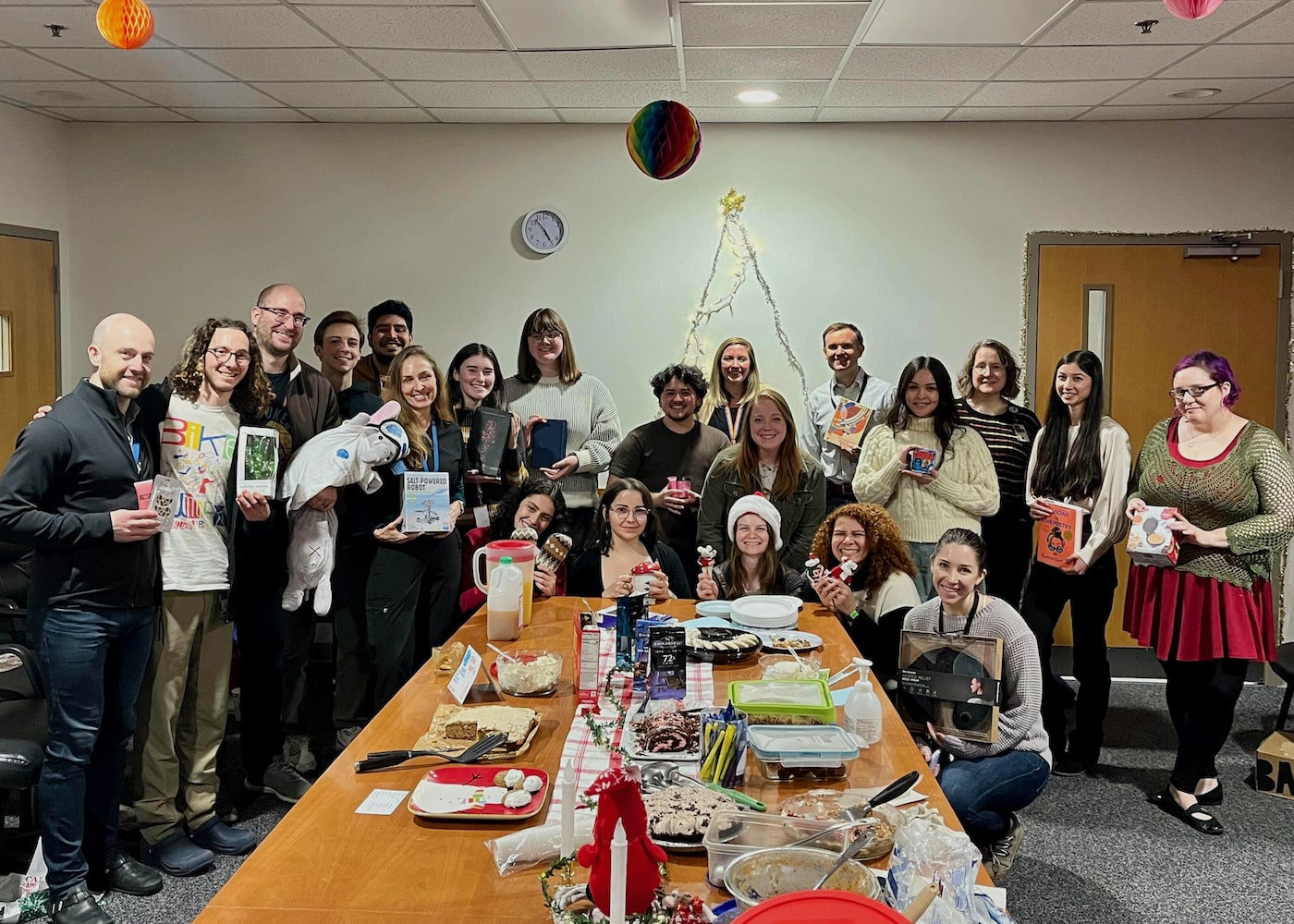 SHARP lab members smiling holding gifts from a holiday gift swap game